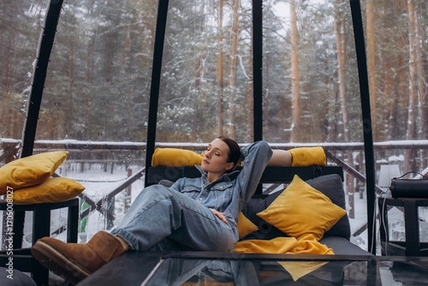 Obraz A woman is relaxing inside a domed tent at a glamping in the forest