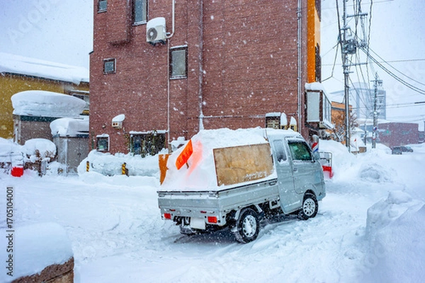 Fototapeta 雪国の生活：雪まみれの住宅地では毎日積もった雪を捨てるための軽トラックが必需品