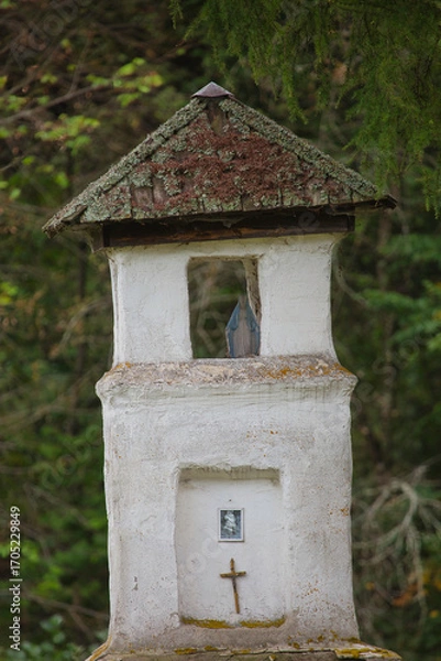 Fototapeta A small white building with a cross on top and a window