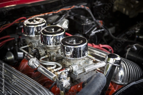 Fototapeta Under the Hood View of Restored Vintage Automobile Engine with Tri-Power Show-Chrome Carburetors