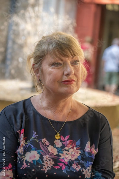 Fototapeta femme âgée en vacances assise devant une fontaine