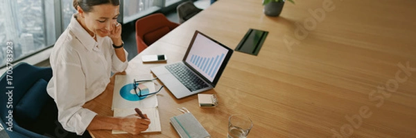 Fototapeta A businesswoman is diligently analyzing key financial data in a modern office environment