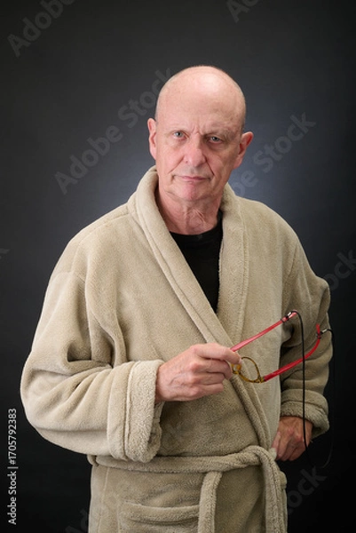 Fototapeta Closeup portrait of a serene aged and balded man in bathrobe