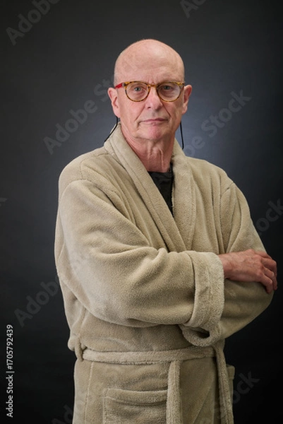 Fototapeta Closeup portrait of a serene aged and balded man in bathrobe