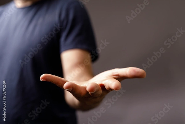 Fototapeta Close-up image of a man's hand outstretched, symbolizing help, support, giving, and receiving. Perfect for concepts of charity, donation, and care.