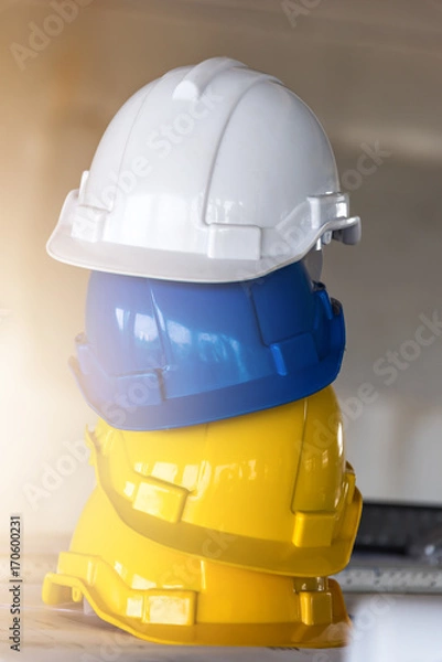 Obraz Stack of Safety helmets,white,Blue and yellow helmets in construction site.