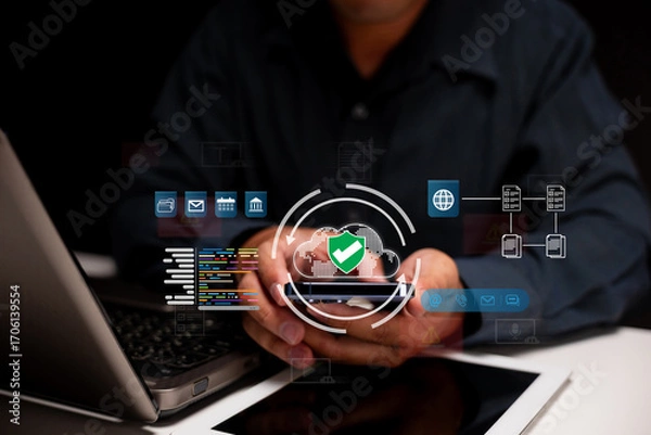 Fototapeta A person using a laptop with digital security icons overlay, emphasizing technology and cybersecurity.