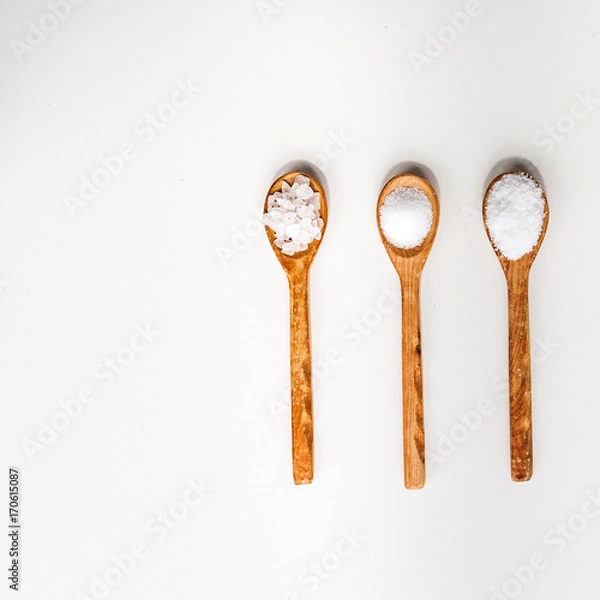 Fototapeta Different types of salt. Top view on black in wood spoons. Copy space..