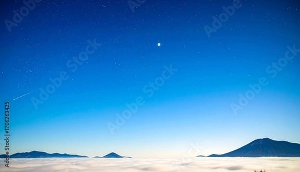 Fototapeta Vast expanse of a clear night sky above a sea of clouds, with distant mountains