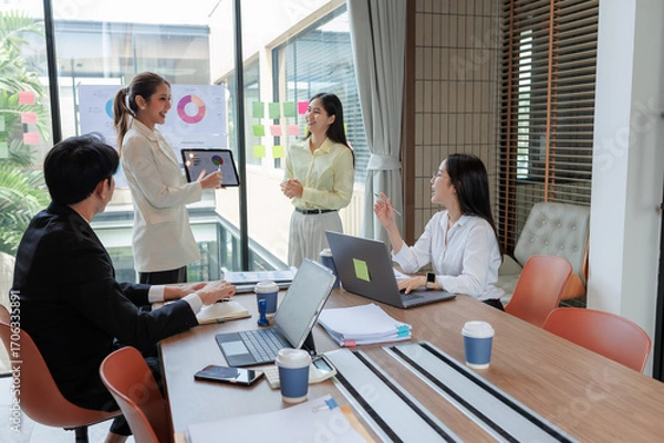 Fototapeta Employees presenting sales data during a business meeting.