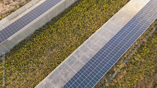 Fototapeta Aerial view of modern solar greenhouses with photovoltaic panel roofs, sustainable agriculture and renewable energy integration for eco farming and clean power production