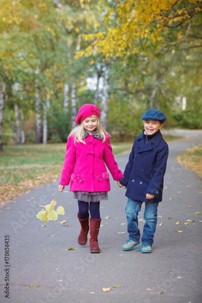 Fototapeta Children walking in beautiful autumn park on warm sunny fall day.