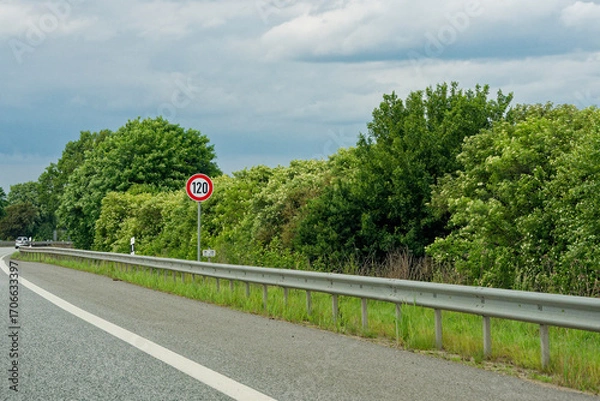 Fototapeta Autobahn with guardrails and speed limit sign one two zero