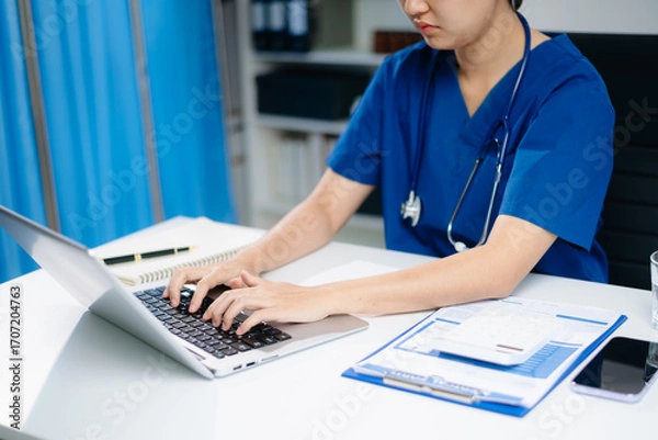 Fototapeta Healthcare costs and fees concept.Hand of smart doctor used a calculator and smartphone, tablet for medical costs at hospital in morning light