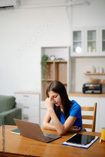 Fototapeta Asian business woman is stressed, bored, and overthinking from working on a tablet