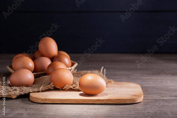 Fototapeta Fresh organic eggs from the farm are placed on a wooden table in the kitchen for preparing breakfast. Healthy food.