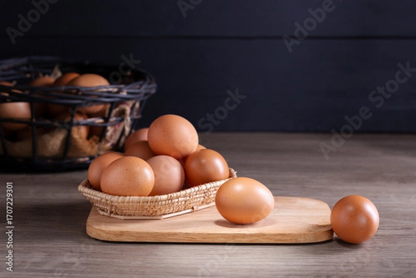 Fototapeta Fresh organic eggs from the farm are placed on a wooden table in the kitchen for preparing breakfast. Healthy food.