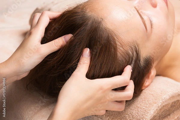 Fototapeta 若いアジア人女性はヘッドマッサージを受けています。