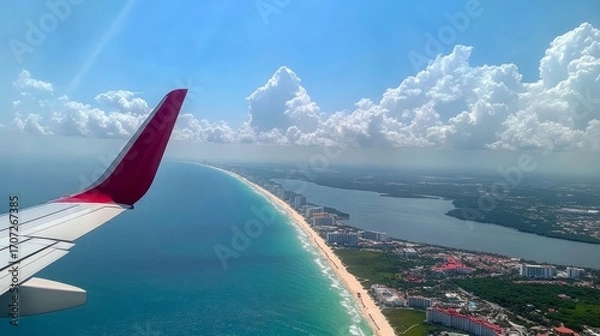 Fototapeta Looking out the plane window, you can see the wing. Below is the Mexican coast with Cancun's hotels in Quintana Roo.
