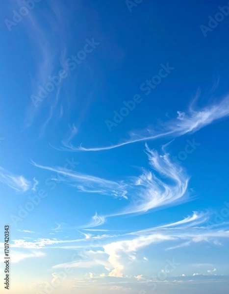 Obraz Wispy clouds against a vibrant blue sky