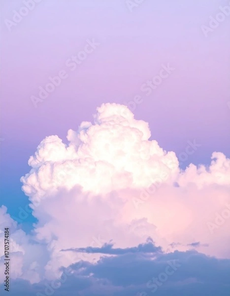 Fototapeta Majestic white cloud floats below a pastel sky, transitioning from blue to violet, creating an ethereal, dreamy atmosphere in vertical view