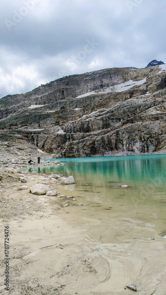 Fototapeta Austria, 08-2025 : wide shot of a glacial lake, near the weißsee lake. Moutains and cloudy sky in background.