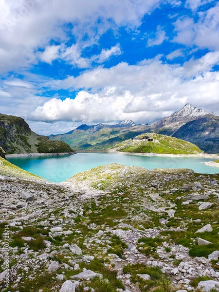 Fototapeta Austria, 08-2025 : wide shot of Weißsee lake, mountains and glaciers in background, mountain rocks in foreground.