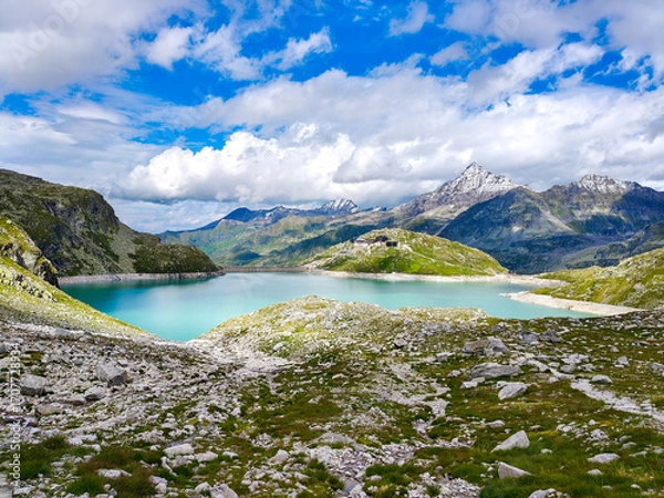 Fototapeta Austria, 08-2025 : wide shot of Weißsee lake, mountains and glaciers in background, mountain rocks in foreground.