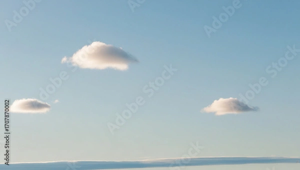 Fototapeta Daytime sky, clear blue gradient, few soft fluffy white clouds, minimalist clean background, calming and simple