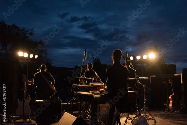 Obraz Backlit shot of a small rock band in concert