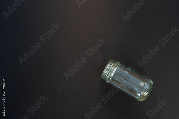 Fototapeta Empty Glass Jar Without Lid on Black Background with Blank Space for Text.