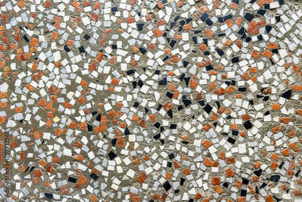 Fototapeta Fragment of an ancient decorative mosaic on the floor, close up. Broken ceramic tiles, brick and stone parts with cement grout wall decor. Abstract textured background.