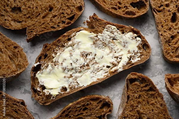 Fototapeta Artisan sliced rye sourdough bread with butter top view. Food backgrounds