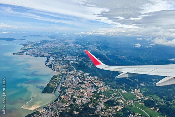 Fototapeta Aerial view from an airplane window showing the cityscape, coastline, and mountains of Kota Kinabalu, Sabah, Malaysia.