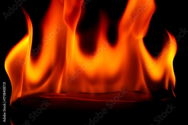 Fototapeta Vibrant Flames Dance in a Dark Background Creating Intense Heat