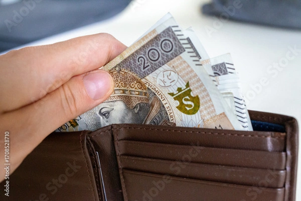 Obraz Hand pulling Polish złoty banknotes from wallet