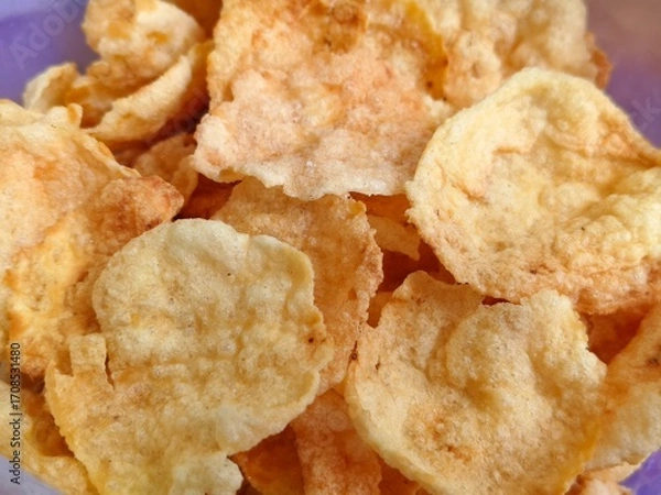 Fototapeta Close-up of crispy fried melinjo chips with a golden brown texture and crunchy appearance.