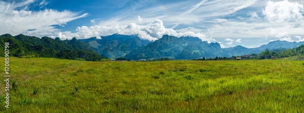 Fototapeta Scenic view of the grass field lawn with peaceful Mountains, Beautiful Scenery landscape with green hills in spring time. illustrating the idea of travel, tourism or exploring