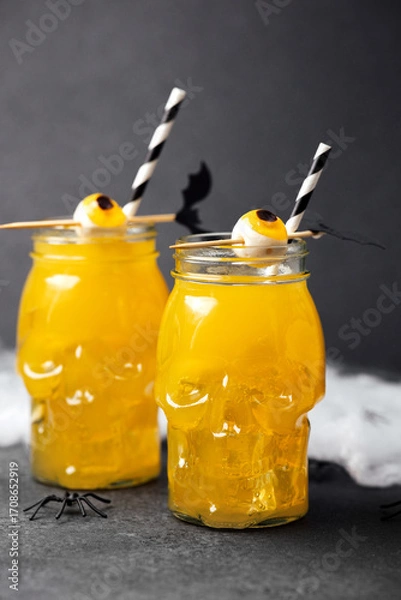 Fototapeta Two Halloween drinks in skull glasses with eyeball garnishes and striped straws