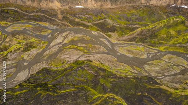 Fototapeta Volcanic Iceland terrain with braided river channels spreading through barren rocky valley seen from drone perspective during summer