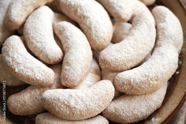 Fototapeta Close up of homemade Christmas cookies called Kipferl or vanilla crescents coated in sugar