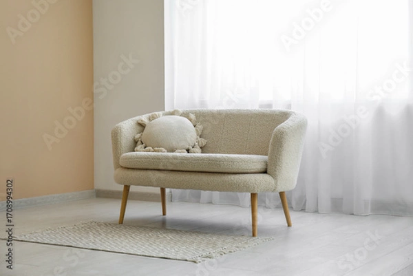 Fototapeta Comfortable sofa with carpet and light curtain in interior of living room