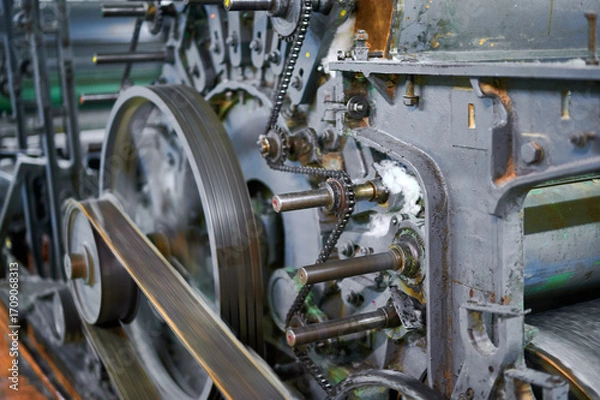 Fototapeta Exploring the intricate mechanisms of a carding machine in an industrial textile workshop during the morning hours