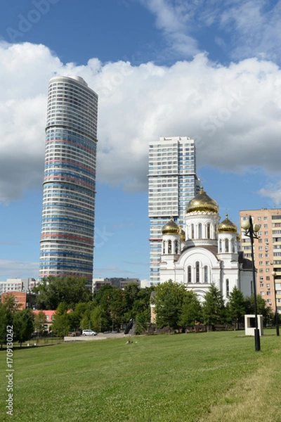 Fototapeta View of the Tricolor residential complex and the Church of the Holy Equal-to-the-Apostles Methodius and Cyril from Aqueduct Park in the Rostokino district of Moscow