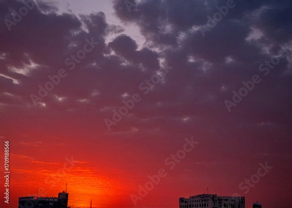 Fototapeta Lahore skyline at sunset with ominous red sky and dramatic motion, capturing the city's silhouette against a vibrant orange and pink hues backdrop,