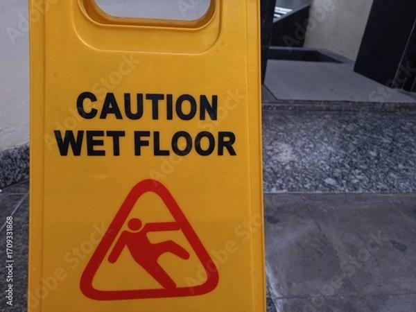 Fototapeta A yellow board is used to inform that the area is in the process of being cleaned