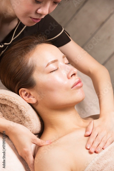 Fototapeta 若いアジア人女性はデコルテのマッサージを受けています。