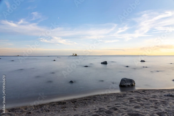 Obraz A tranquil sunset over Tiny Beach, Ontario, with serene waters reflecting the vibrant sky.
