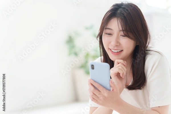 Obraz スマホを使う若い女性