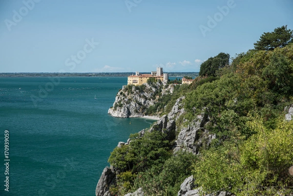 Fototapeta Duino Castle, a fortification of the 14th century in the Gulf of Trieste, seen from a panoramic footpath called Rilke trail. Northeastern Italy, Europe.